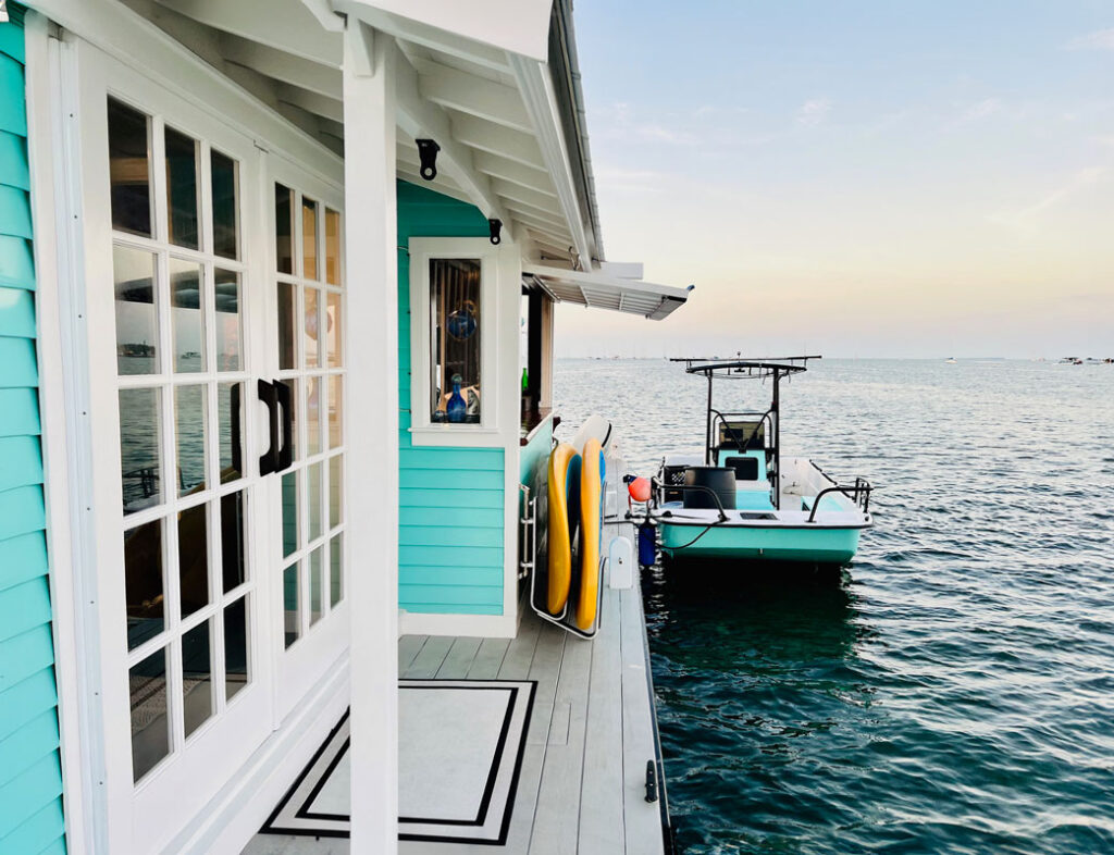 photo of the front door of a houseboat with a skiff parked outside