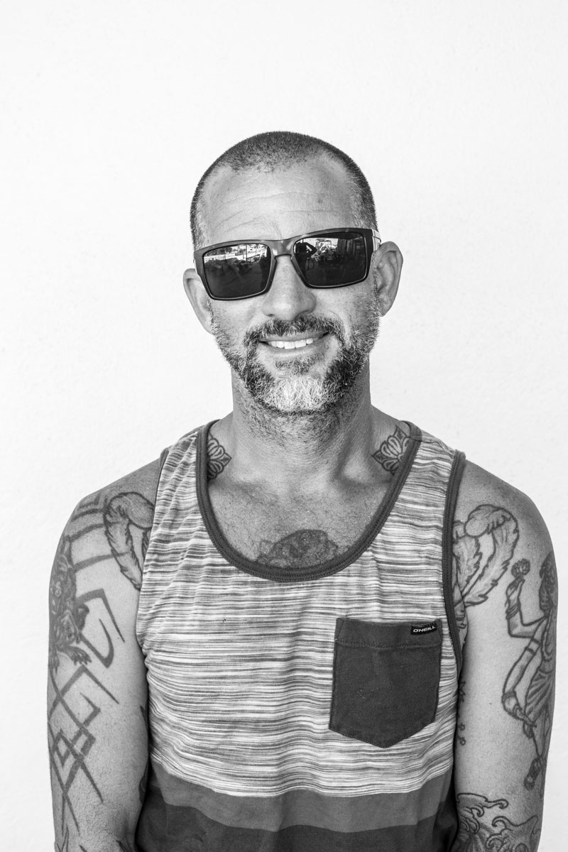 portrait photo in black and white of a man with tattoos
