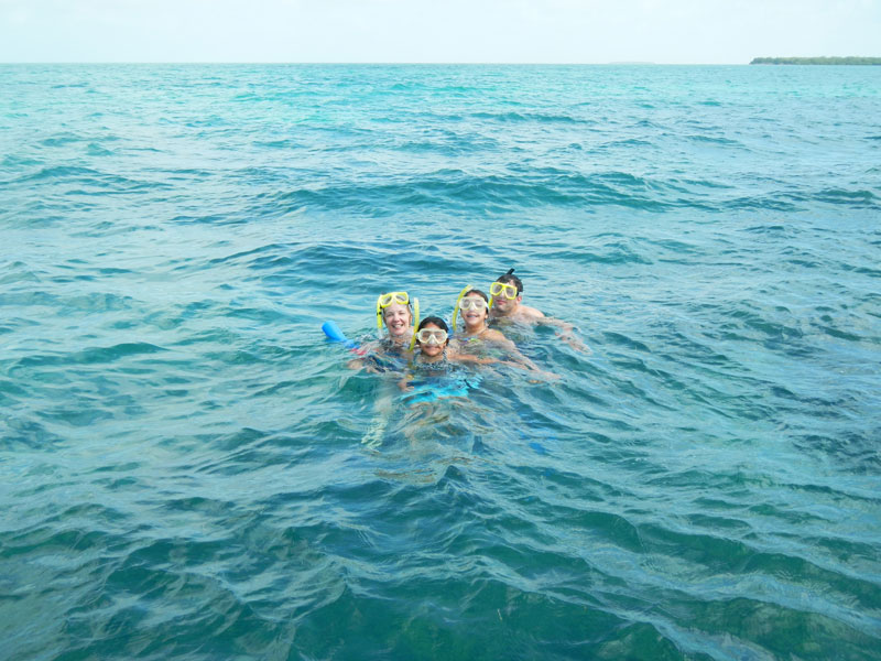 photo of tourists floating in water smiling with snorkel gear