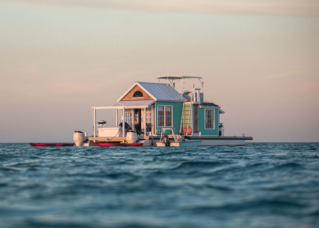 photo of a houseboat called the outpost on open water